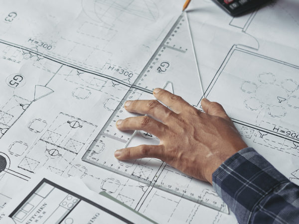 Hands of architect drawing blueprint of the house